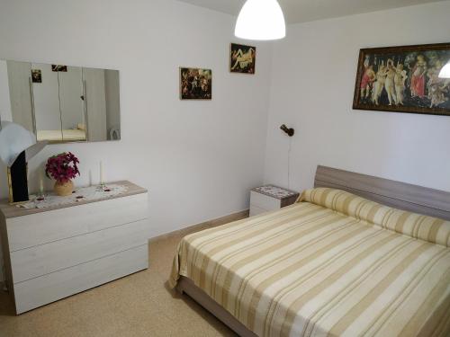 1 dormitorio con cama, tocador y espejo en Villa Olimpo B&B, en Fasano