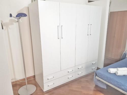 a white cabinet in a bedroom with a bed at Oly99 in Palermo