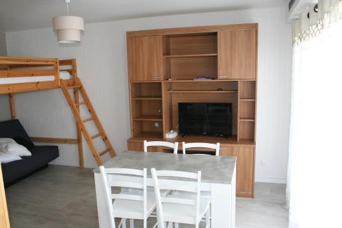 - un salon avec une table, des chaises et des lits superposés dans l'établissement calypso 2, à Berck-sur-Mer