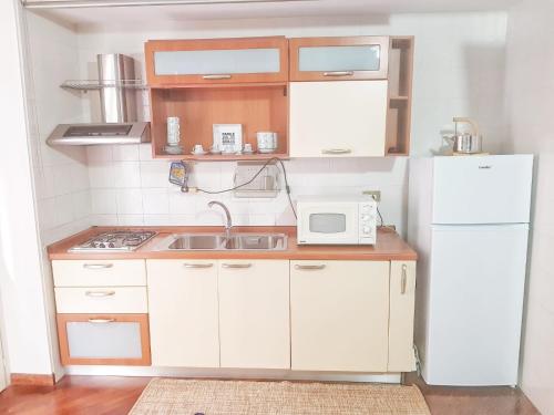 eine kleine Küche mit Spüle und Kühlschrank in der Unterkunft Oly99 in Palermo