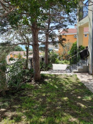 a tree in the grass next to a building at Vila Maljevik in Sutomore