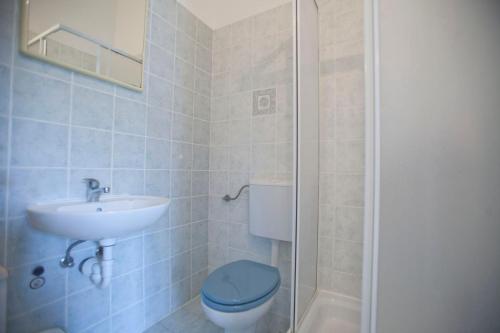Un baño con un inodoro azul y un lavabo. en Apartment Ana, en Fažana