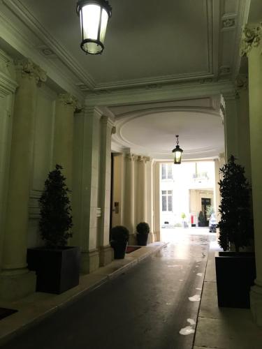 un couloir vide avec des plantes en pot dans un bâtiment dans l'établissement Parc Monceau, à Paris