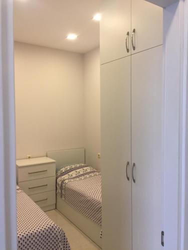 a bedroom with two beds and white cabinets at Belle Vue Apartment in Batumi