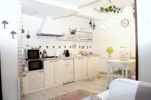 a small kitchen with white cabinets and a table at Villa Luna Lombarda in Salò
