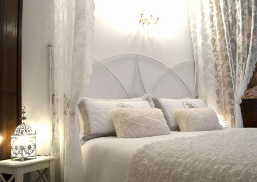 a bedroom with a white bed with white curtains at Villa Luna Lombarda in Salò