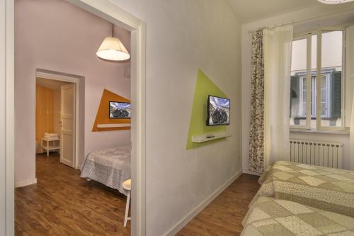 a small room with two beds and a window at Affittacamere del Centro in Lucca