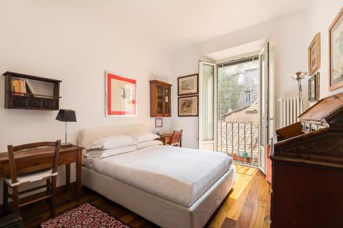 Un dormitorio con una cama, un escritorio y un piano. en R.C. Cappellari Charming Campo de Fiori, en Roma