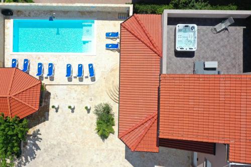 an overhead view of a swimming pool with umbrellas and chairs at Villa Magnolia in Privlaka