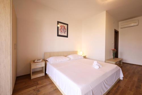 a bedroom with a large white bed with two pillows at Villa Magnolia in Privlaka