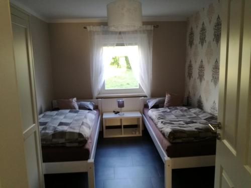 2 Betten in einem kleinen Zimmer mit Fenster in der Unterkunft Bella Casa in Laufenburg