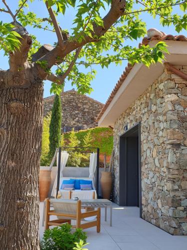a patio with a table and a tree at Mas de la Petite Jeanne in Grimaud