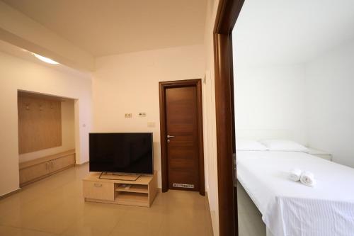 a bedroom with a bed and a flat screen tv at Villa Magnolia in Privlaka