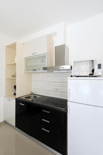 a kitchen with a white refrigerator and a sink at Villa Magnolia in Privlaka