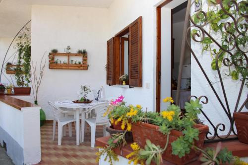 a patio with a table and some flowers in pots at Litto Appartamenti in Tropea