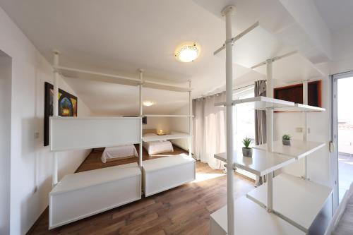 a bedroom with white walls and white bunk beds at Villa Magnolia in Privlaka