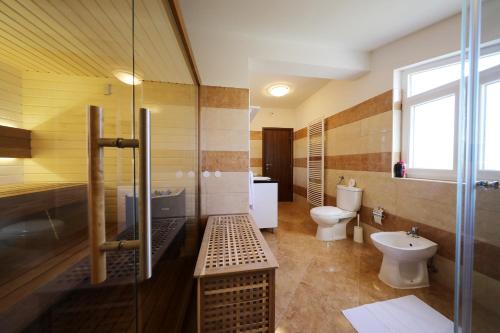 a bathroom with a glass shower and a toilet at Villa Magnolia in Privlaka