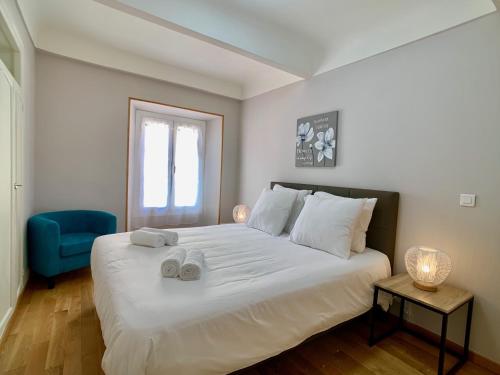 - une chambre avec un grand lit blanc et une chaise bleue dans l'établissement Palais Massena - Easy Home Booking, à Nice