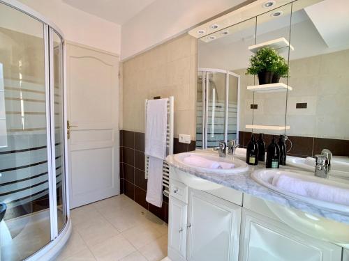une salle de bain avec deux lavabos et un grand miroir dans l'établissement Palais Massena - Easy Home Booking, à Nice