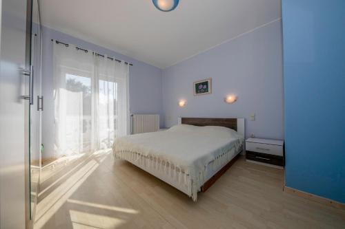 een slaapkamer met een bed en een groot raam bij Apartment Marina in Rab