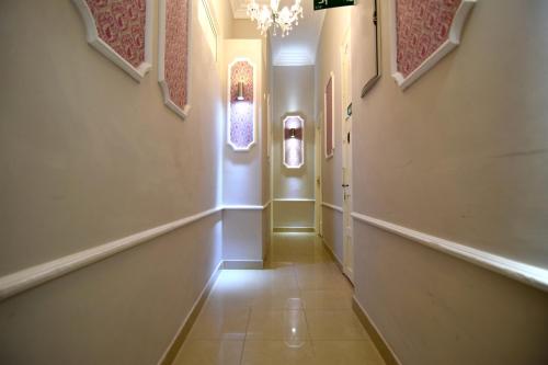 a hallway with two windows and a chandelier at Apartamentos Marques De La Merced in Málaga