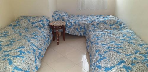 a room with a bed and a table and a stool at Maison traditionnelle marocaine in Rabat