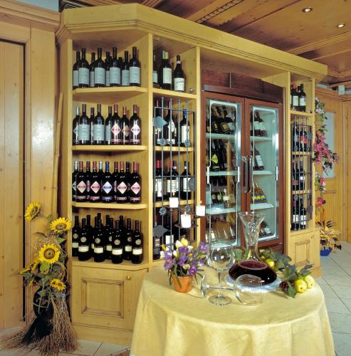 a room with a table with bottles of wine at Hotel Diamant Park in Campitello di Fassa