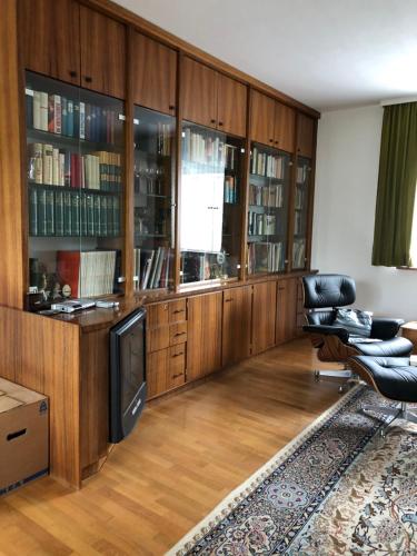 a living room with leather chairs and a television at K House 5* Apartments in Kaufungen