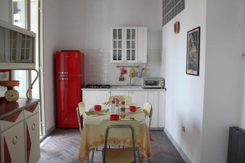 eine Küche mit einem Tisch und einem roten Kühlschrank in der Unterkunft Lacasadilu in Neapel