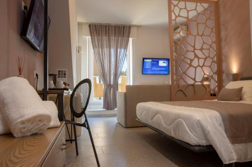 a bedroom with a bed and a couch and a television at Hotel Stella Del Mare in Chiavari