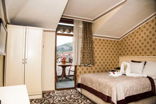 a bedroom with a bed and a window and a table at Nazar Hotel in Trabzon