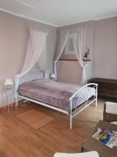 sypialnia z białym łóżkiem z zasłonami w obiekcie Gîte du mont de transet w mieście Thauron