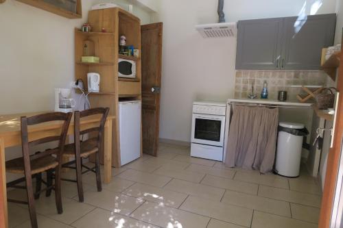 - une cuisine avec des appareils blancs, une table et des chaises dans l'établissement EXCEPTIONNEL, maison de vacances dans parc, climatisation, parking, calme assuré, à Marseille