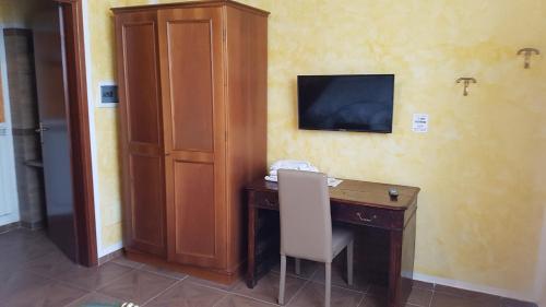 a room with a desk with a television on a wall at Agriturismo La Fornace centro ippico in Como