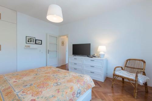 1 dormitorio con 1 cama y vestidor con TV en Apartment Cankar, en Pula