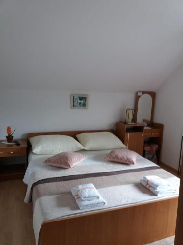 a bedroom with a bed with two towels on it at Guesthouse Tomas in Čatrnja