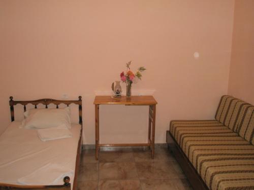 a bedroom with a bed and a table with flowers on it at faliraki apartments in Benitses