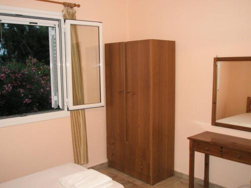 a bathroom with a cabinet next to a window at faliraki apartments in Benitses