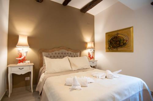 - une chambre avec un grand lit blanc et des serviettes dans l'établissement Relais Bijoux Napoli, à Naples
