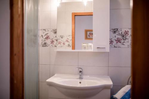 ein weißes Badezimmer mit Waschbecken und Spiegel in der Unterkunft kažo in Rab