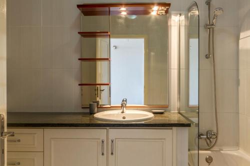 une salle de bain avec lavabo et douche dans l'établissement The Hoffy Beach Apartment, à Lagos