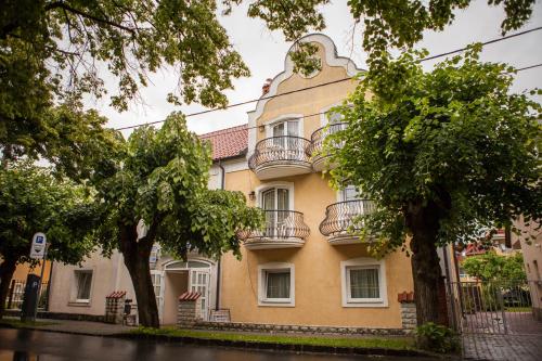a yellow building with balconies on the side of it at Villa Mediterran in Hévíz
