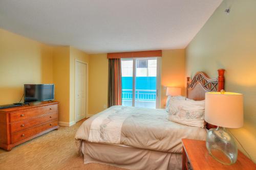 um quarto com uma cama, uma televisão e uma janela em Horizon at 77th Avenue North by Palmetto Vacations em Myrtle Beach