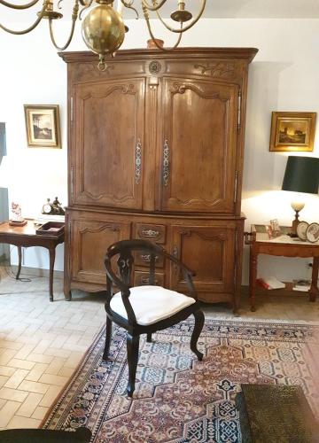 Cette chambre comprend une chaise et une grande armoire en bois. dans l'établissement Sublime appartement Volendame, à Dijon