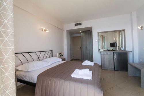 a bedroom with a bed with two towels on it at Anesis Hotel in Agia Pelagia Kythira