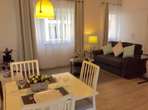 a living room with a table and chairs and a couch at CHARMING LIDO FLAT II in Funchal