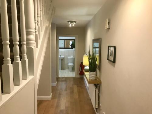 a hallway with a bathroom with a toilet and a staircase at 4 bed Duplex Apartment, Belfast in Belfast
