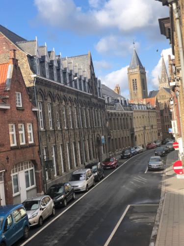 uma rua da cidade com carros estacionados em frente aos edifícios em Inga em Ypres
