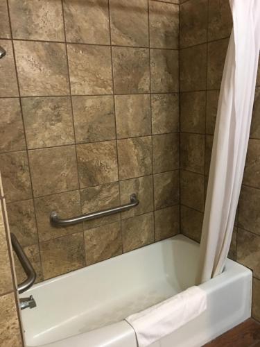 a shower with a bathtub with a shower curtain at Southfork Motel in Bloomfield