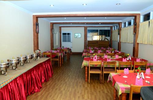 un comedor con mesas con mantel rojo en Lakezone Holiday Resort, en Chinnakanal